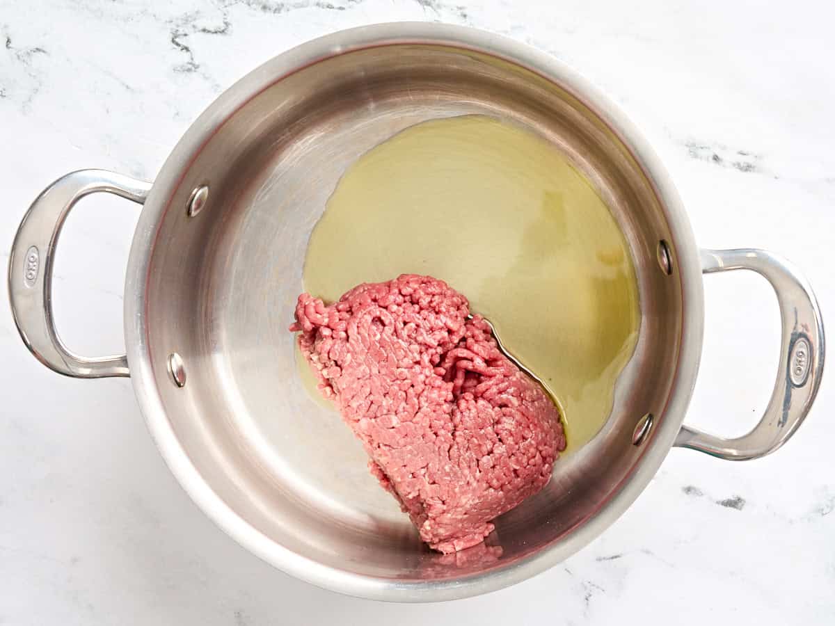 Ground beef and oil in a skillet.