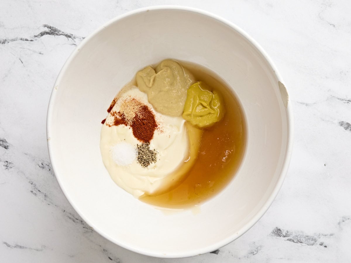 Mayo, mustard, honey, apple cider vinegar, and seasonings in a bowl.
