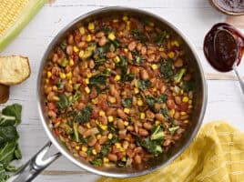Overhead view of a skillet of bbq beans and greens.