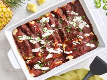 Overhead view of beef enchiladas in a baking dish.