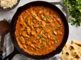 Overhead view of a homemade butter chicken in a cast iron skillet.