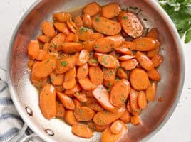 Overhead view of glazed carrots in a sauté pan.