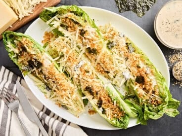 Overhead view of grilled romaine Caesar salad on a serving platter.