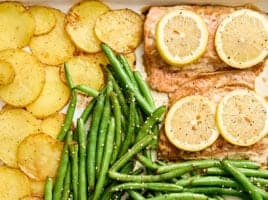 Overhead view of a one pan salmon dinner on a baking sheet.