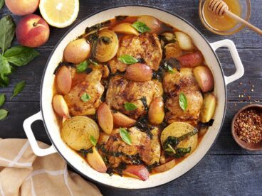 Overhead view of savory braised peach chicken in a skillet.