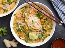 Overhead view of thai vegetable curry soup in a bowl with chopsticks.