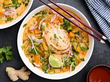 Overhead view of thai vegetable curry soup in a bowl with chopsticks.