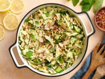 Overhead view of a bowl of zucchini, corn and toasted almond salad.